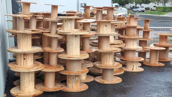 Stacks of empty wooden cable reels in a yard