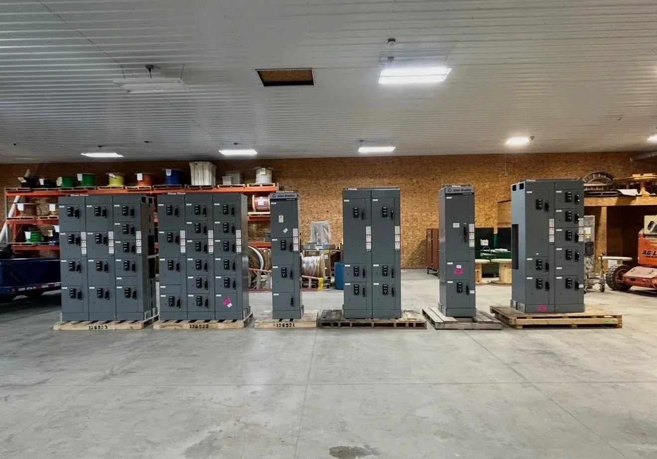 Row of switchboards on pallets in a warehouse