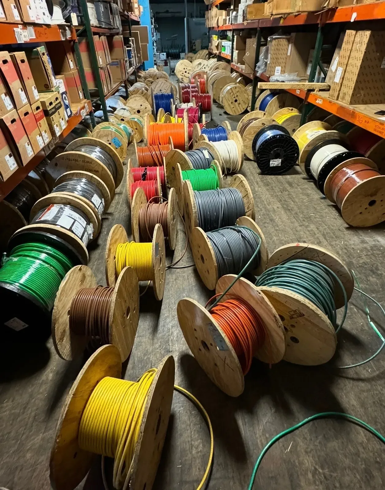 Partial reels of colored electrical wire on a warehouse floor