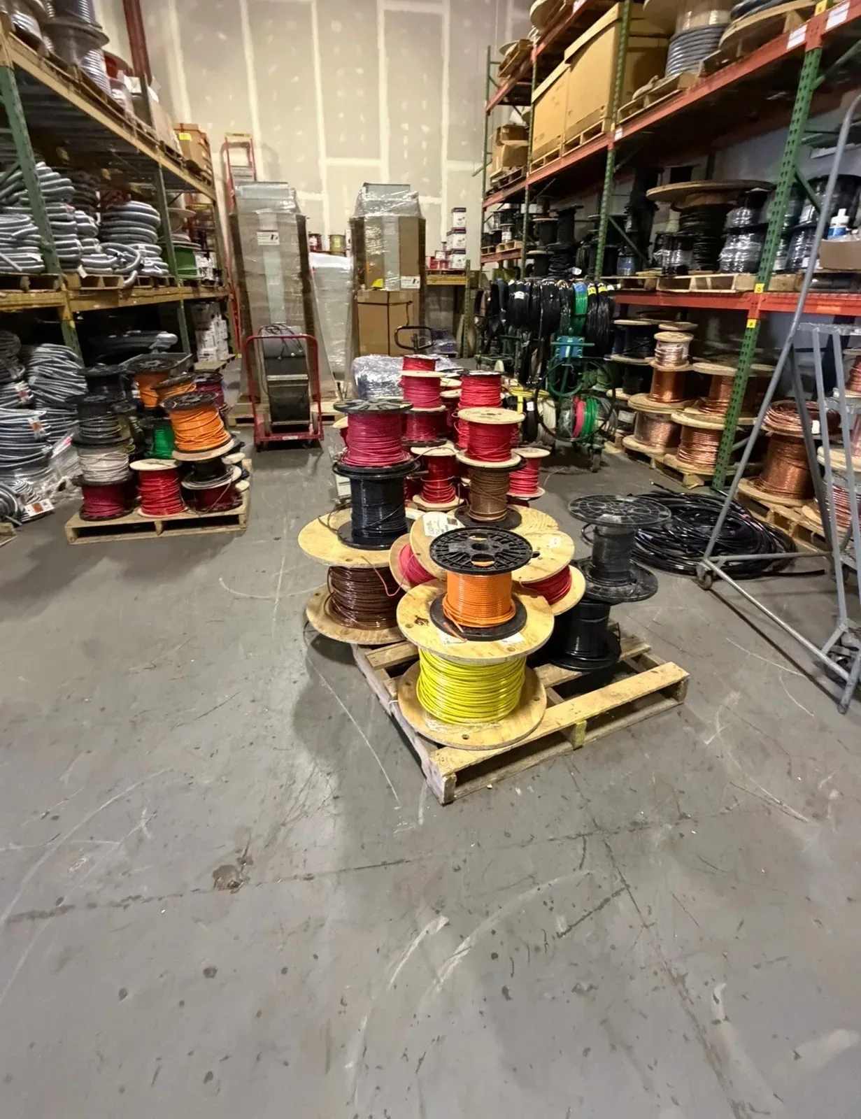 Partial wire reels stacked on a pallet in a warehouse
