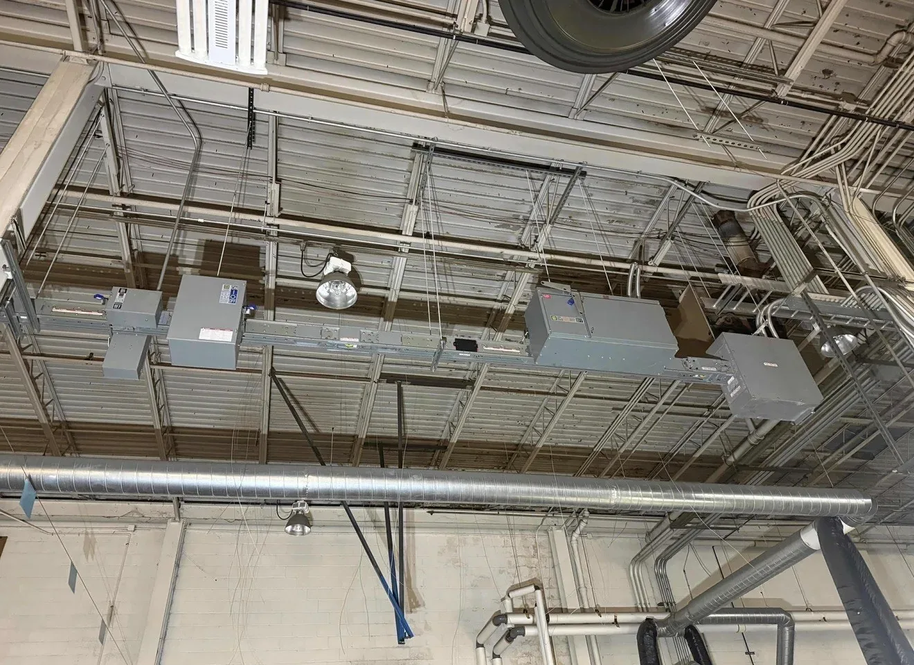Overhead busway with bus plugs in a warehouse